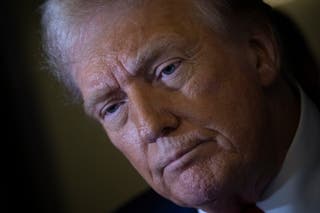Donald Trump listens to a question while speaking to members of the press while returning to Washington DC on Air Force One